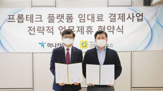 임현빈 하나카드 마케팅본부장(왼쪽)이 지난 29일 서울 강남구에 위치한 스마트하우스 본사에서 열린 업무협약식에서 김민수 스마트하우스 대표와 기념촬영을 하고 있다.(하나카드 제공)